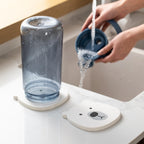 Large diatomaceous earth coaster with bear print absorbing water from a bottle after rinsing 