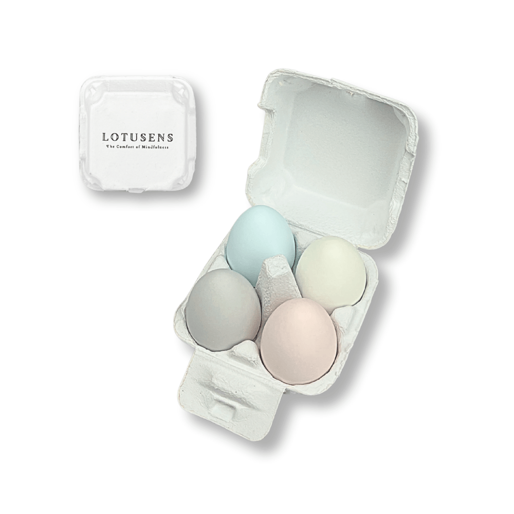 Pastel-colored diatomite dehumidifying eggs in a white egg holder with 'LOTUSENS' branding on a white background