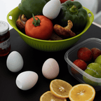 Green colander with vegetables and diatomite drying eggs on a dark table