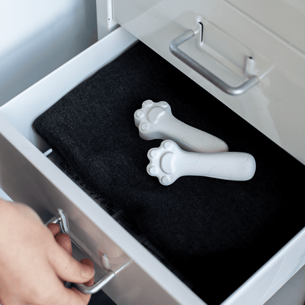 Two white paw-shaped diatomite drying blocks in a drawer